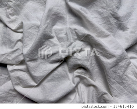 crumpled white cotton fabric twists gracefully over pale blue surface evoking serene minimalism perfect for abstract wallpaper or clean copy space banner 134613410