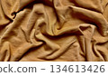 golden brown fabric texture wrinkles softly in closeup folds evoking warm luxurious depth for wallpaper or banner background 134613426