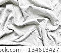 elegant white fabric crumpled in soft rippling folds on pastel blue surface evoking serene minimalism perfect for abstract wallpaper or copy space banner 134613427