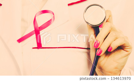 Pink ribbon with stethoscope on medical uniform. Pink ribbon with stethoscope on medical uniform. 134613970