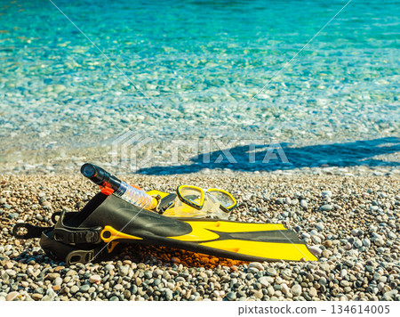 Flippers and snorkeling tube on sea shore Flippers and snorkeling tube on sea shore 134614005