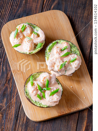 Avocado halves filled with guacamole and shrimp topped with spicy sriracha mayo 134614102