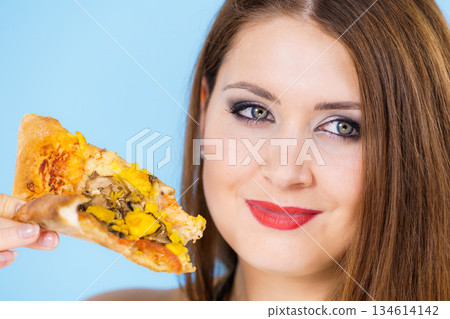 Woman eating hot pizza slice Woman eating hot pizza slice 134614142