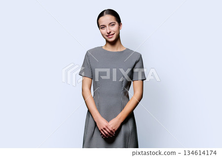 Beautiful young woman in dress looking at camera on white background 134614174