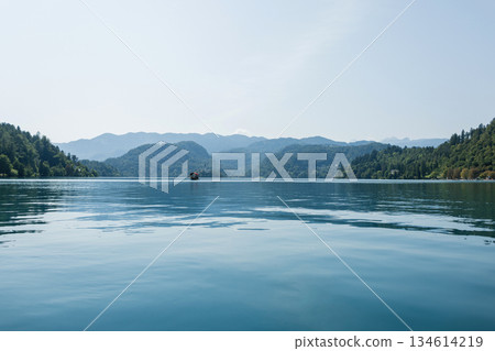 Scenic view of Lake Bled with calm blue water, surrounded by green hills and distant mountains under a clear sky, capturing the beauty of nature and peaceful travel destinations. Old church Scenic view of Lake Bled with calm blue water, surrounded by green hills and distant mountains under a clear sky, capturing the beauty of nature and peaceful travel destinations. Old church 134614219
