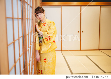A young woman wearing a kimono standing by a shoji screen in a Japanese-style room A young woman wearing a kimono standing by a shoji screen in a Japanese-style room 134614233