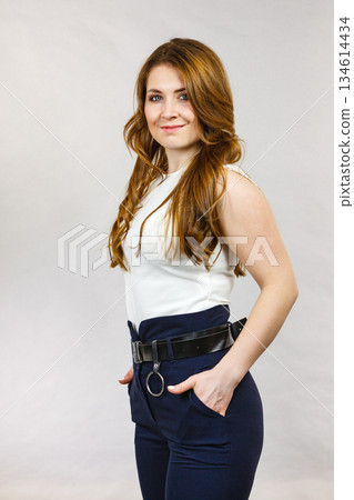Woman wearing high waist trouser with belt 134614434
