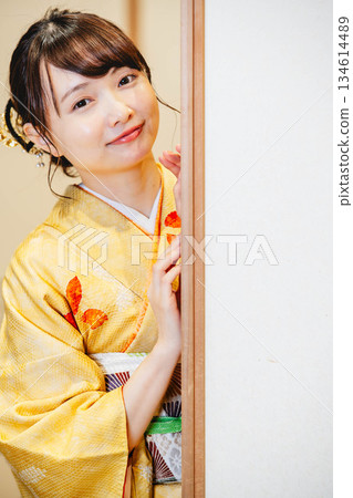 一位身穿和服的年輕女子打開了日式房間的拉門。 一位身穿和服的年輕女子打開了日式房間的拉門。 134614489