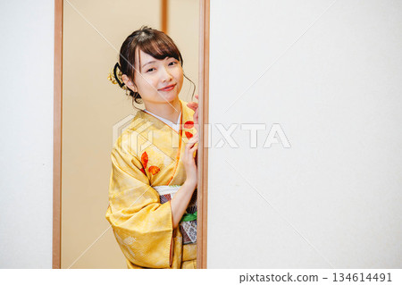 一位身穿和服的年輕女子打開了日式房間的拉門。 一位身穿和服的年輕女子打開了日式房間的拉門。 134614491