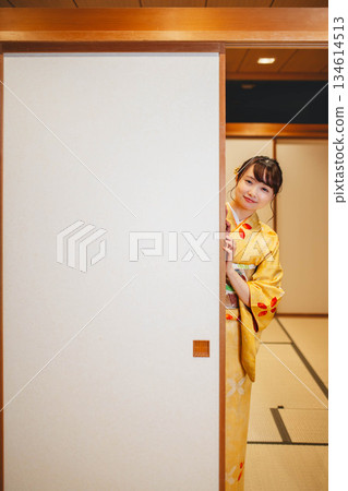 A young woman in a kimono opening a sliding door in a Japanese-style room A young woman in a kimono opening a sliding door in a Japanese-style room 134614513