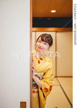 A young woman in a kimono opening a sliding door in a Japanese-style room A young woman in a kimono opening a sliding door in a Japanese-style room 134614521
