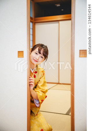 一位身穿和服的年輕女子打開了日式房間的拉門。 134614544