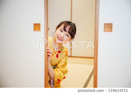 A young woman in a kimono opening a sliding door in a Japanese-style room A young woman in a kimono opening a sliding door in a Japanese-style room 134614551