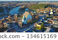 Porvoo, Finland - December 08, 2020: Aerial perspective of a picturesque village featuring a historic church and winding river, surrounded by lush greenery and colorful houses 134615169