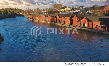 Porvoo, Finland - December 08, 2020: Scenic view of a river lined with charming red wooden houses, reflecting on the water surface under a beautiful sky Porvoo, Finland - December 08, 2020: Scenic view of a river lined with charming red wooden houses, reflecting on the water surface under a beautiful sky 134615170