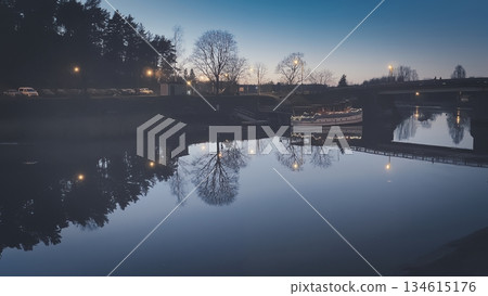 Porvoo, Finland - December 08, 2020: Scenic view of a river at dusk, showcasing reflections of trees and lights along the water, creating a tranquil evening atmosphere Porvoo, Finland - December 08, 2020: Scenic view of a river at dusk, showcasing reflections of trees and lights along the water, creating a tranquil evening atmosphere 134615176