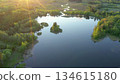 Aerial perspective showcasing a tranquil lake with small islands, bordered by vibrant green trees and a winding river, capturing the beauty of nature and peaceful outdoor scenery. Ao, Estonia. 134615180