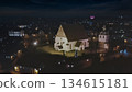 Porvoo, Finland - December 08, 2020: Aerial view of a historic church illuminated at night, surrounded by a quaint village and twinkling lights creating a serene atmosphere 134615181