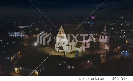 Porvoo, Finland - December 08, 2020: Aerial view of a historic church illuminated at night, surrounded by a quaint village and twinkling lights creating a serene atmosphere Porvoo, Finland - December 08, 2020: Aerial view of a historic church illuminated at night, surrounded by a quaint village and twinkling lights creating a serene atmosphere 134615181