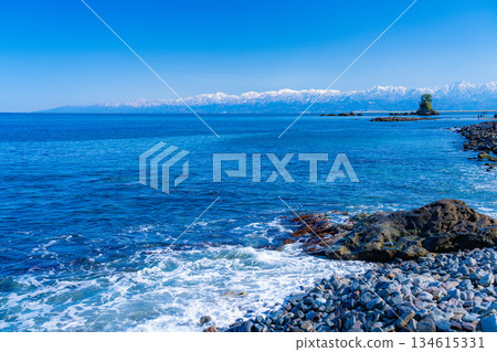 [A winter tradition] A clear winter day on Amaharashi Coast and the snow-capped Tateyama mountain range [Toyama Prefecture] 134615331