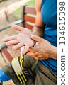 Disabled athlete checking hands after intense workout, mid age man. closeup 134615398