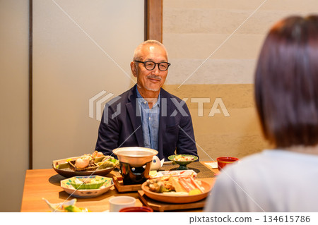 一位老人正在享用日本料理 134615786