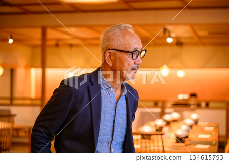 A middle-aged man pondering at a restaurant 134615793