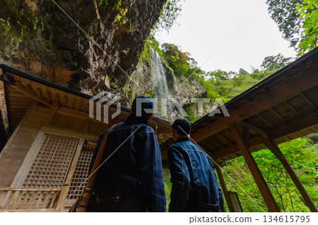 A couple looking up at a waterfall A couple looking up at a waterfall 134615795