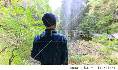男子背對著鏡頭，望著瀑布。 134615873