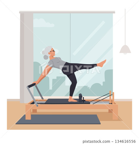 Senior woman practicing pilates reformer exercise at home with city view window 134616556
