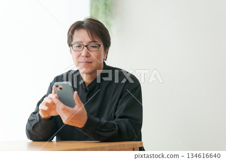 操作智能手機的中年男子 操作智能手機的中年男子 134616640
