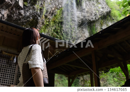 一位女子抬頭望著瀑布。 134617085