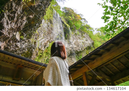 Woman looking up at a waterfall 134617104