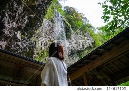 一位女子抬頭望著瀑布。 一位女子抬頭望著瀑布。 134617105