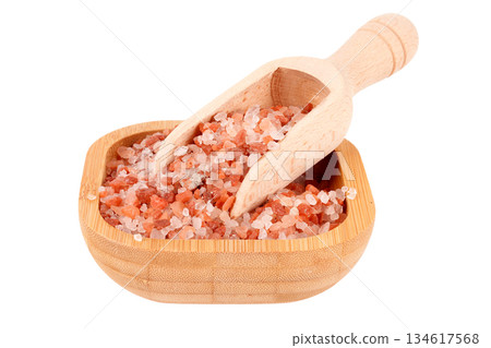 Front view of a wooden bowl and spoon with Himalayan salt crystals isolated on a white background 134617568