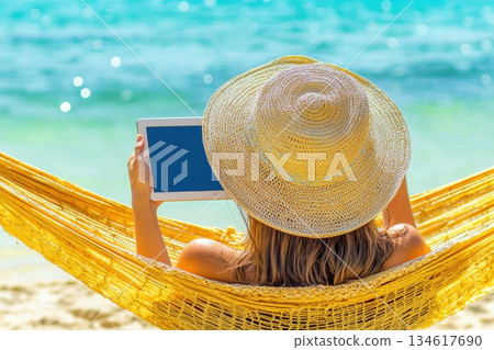 Woman Relaxing in Hammock at Tropical Beach, Working Remotely on a Tablet Device Woman Relaxing in Hammock at Tropical Beach, Working Remotely on a Tablet Device 134617690