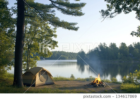 Serene Lakeside Camping Scene with Tent Set Against Tranquil Water and Forest Views 134617869