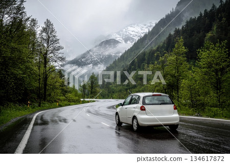 Electric Car Navigating a Winding Mountain Road on a Rainy Day Electric Car Navigating a Winding Mountain Road on a Rainy Day 134617872