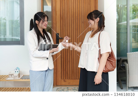 Real Estate. Realtor handing over keys to new homeowner, symbolizing property ownership. Real Estate. Realtor handing over keys to new homeowner, symbolizing property ownership. 134618010