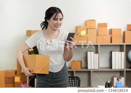 Small Business. Happy entrepreneur checking orders on smartphone. 134618014