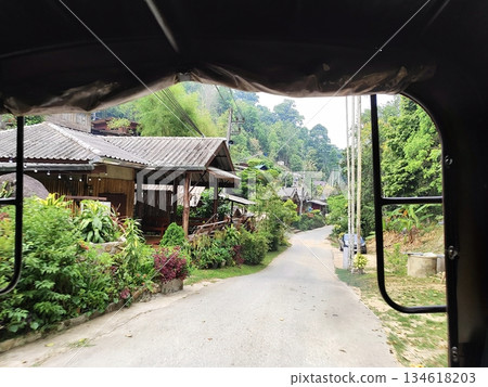 Scenic view of a peaceful mountain village from a vehicle window 134618203