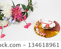 A crepe white horse figurine on a gold fan and New Year's flowers 134618961