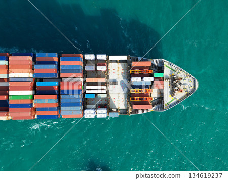 Container ship. Shipping logistics. Commercial shipping. Cargo ship in sea, aerial. Freight container loaded on cargo vessel. Aerial view cargo ship entering harbor. Navigating international waters 134619237