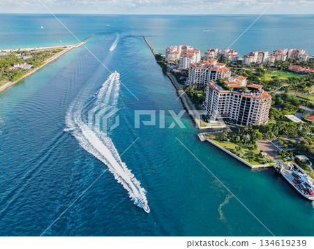 Yacht at Fisher island luxury residential building. Vacation on summer. Fisher island building. Sea canal. Luxury boat motor yacht. Luxury yacht go to marina. Boating and yachting. Luxury lifestyle 134619239