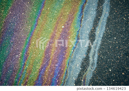 Bright oil slicks create impressive iridescent patterns on asphalt after rain. Bright oil slicks create impressive iridescent patterns on asphalt after rain. 134619423