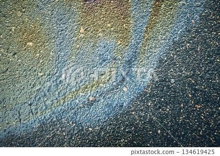 Asphalt road surface showing abstract colorful paint streaks and grunge texture 134619425