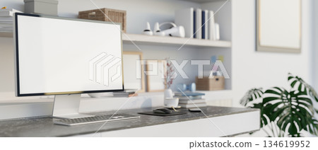 Blank screen computer and books on black marble table in front of a display shelf in white wall room Blank screen computer and books on black marble table in front of a display shelf in white wall room 134619952
