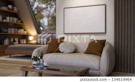 Blank frames on a wall over a leather sofa and glass top table on wooden floor in an attic bedroom. Blank frames on a wall over a leather sofa and glass top table on wooden floor in an attic bedroom. 134619964