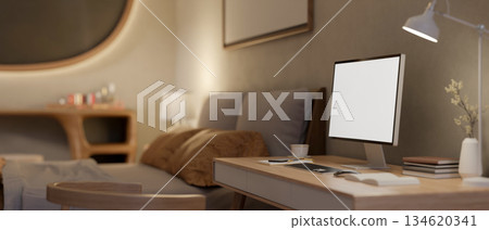 Blank screen computer with books and coffee and lamp aside on wooden table in a dim lit bedroom. Blank screen computer with books and coffee and lamp aside on wooden table in a dim lit bedroom. 134620341