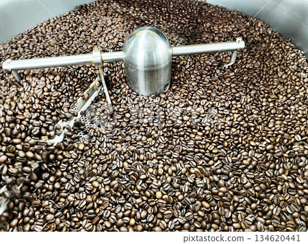 Freshly roasted coffee beans cooling inside an industrial coffee roasting drum, showing texture, aroma, and production process for specialty coffee, food industry, and artisanal roasting concepts 134620441